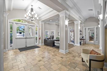 A spacious room with a tiled floor and a chandelier hanging from the ceiling.